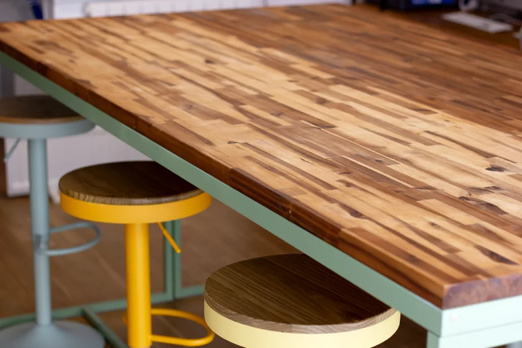 Ma table sur-mesure en acacia et métal, accompagnée de mes tabourets modulables.