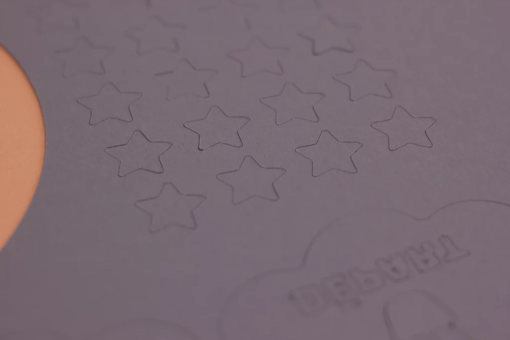 Étoiles découpées dans du papier épais violet lavande à l’aide de ma table de découpe, pour fabriquer le jeu de société "Au royaume des licornes".
