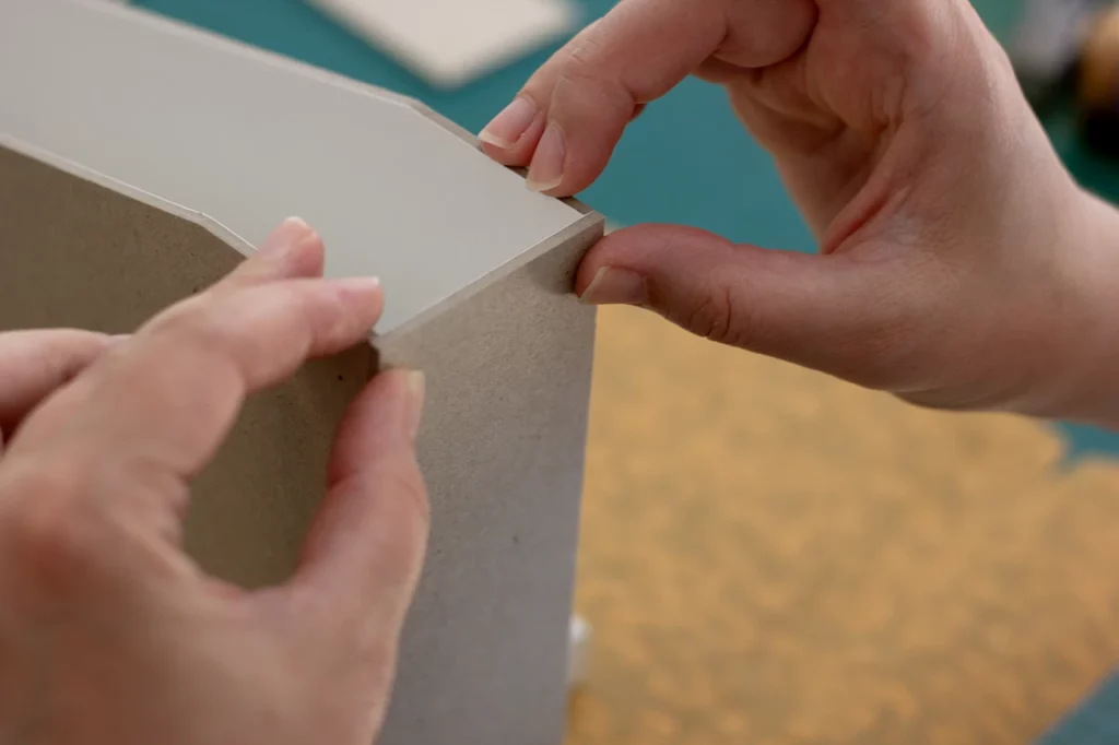 Mise en place du carton gris pour la création d’un porte-revues fait main, recouvert de toile de liège.
