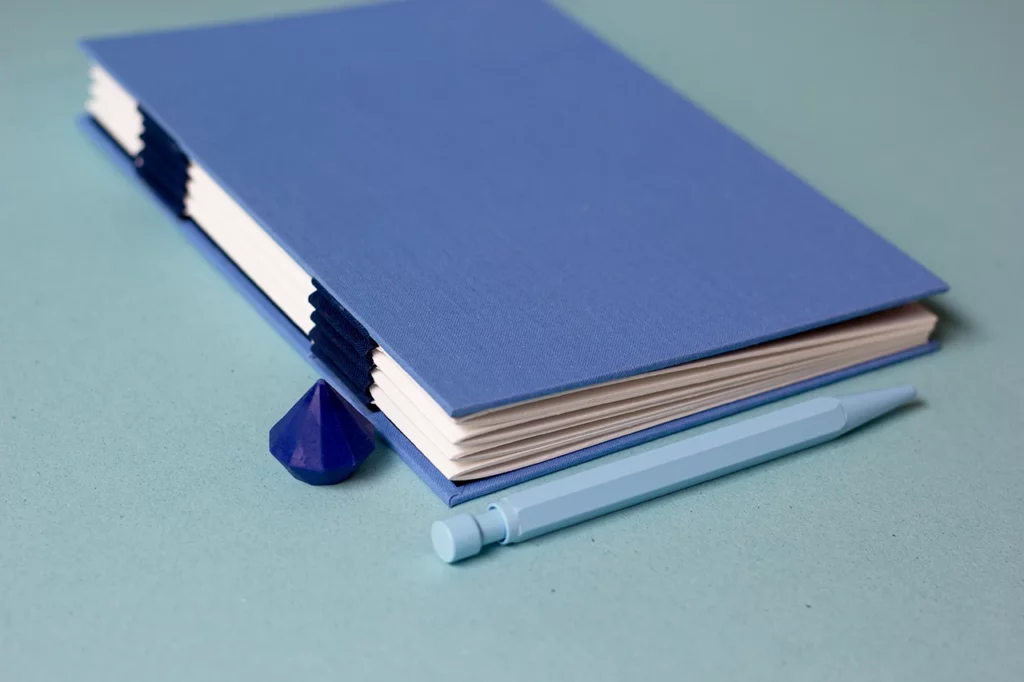 Carnet personnalisé avec une reliure australienne à charnière piano inversée, style plat, réalisé dans mon atelier.