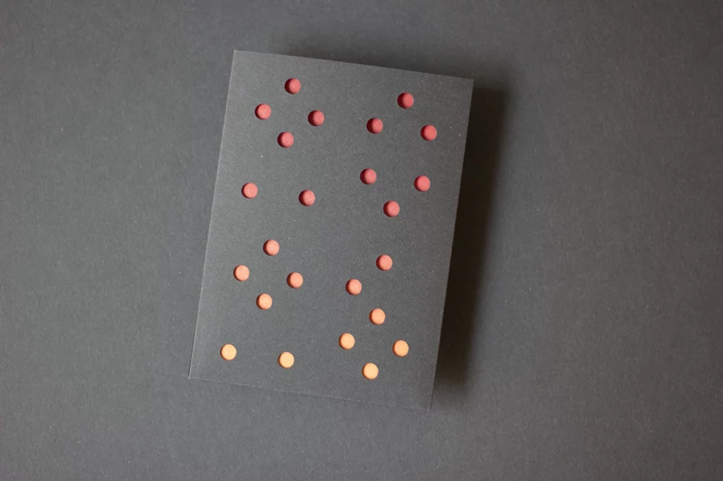 Carte de vœux simple « Planètes 2026 » avec fourreau noir, imprimée en letterpress à l’atelier, avec une création graphique confiée au studio MMONOKL.