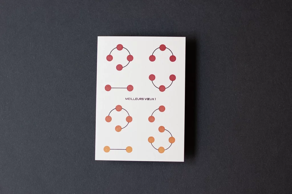 Carte de vœux simple « Planètes 2026 », imprimée en letterpress avec un effet de dégradé rouge et jaune soleil sur les planètes, création graphique MMONOKL.