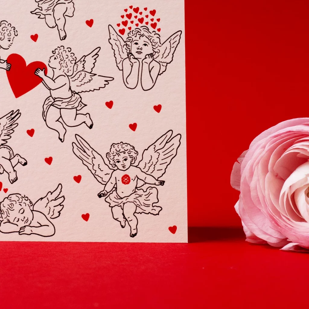 Zoom sur la carte Saint-Valentin – Cupidons & cœurs, imprimée en letterpress à l’atelier Forme contre forme, à Bordeaux, avec une renoncule.