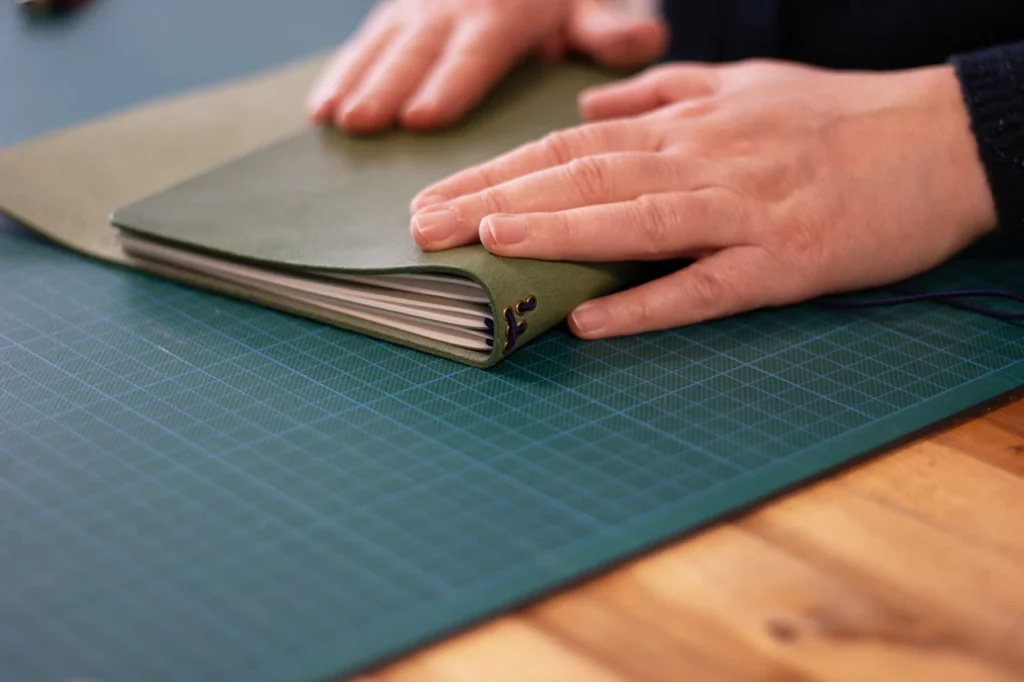 Carnet de voyage en cuir avec trois volets intérieurs pour accueillir trois carnets — réalisé sur mesure à l’Atelier Forme contre forme, Bordeaux.