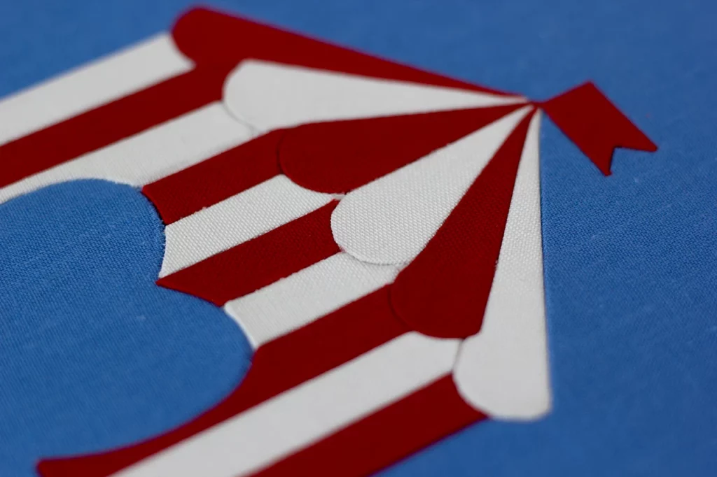 Détail du travail de précision d’une marqueterie de toile sur mesure représentant un chapiteau de cirque — Atelier Forme contre forme, Bordeaux.